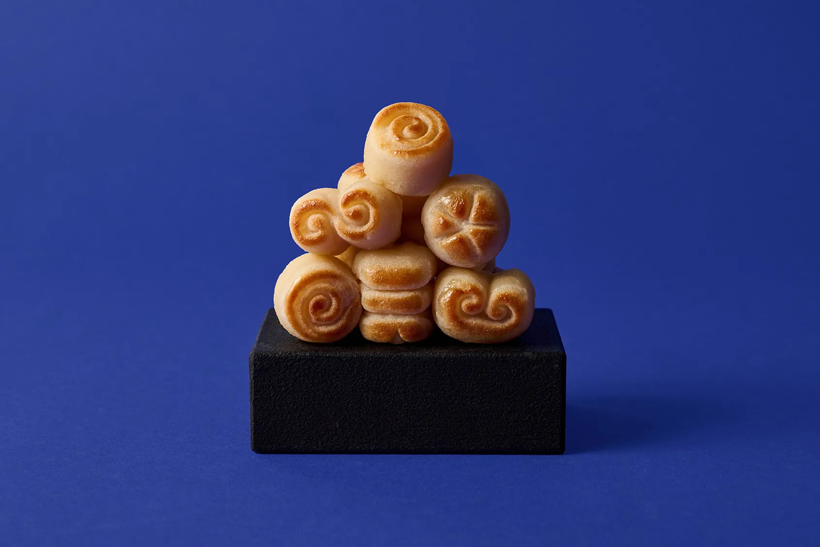 Stimmungsbild: Marzipan Teekonfekt gestapelt auf blauem Hintergrund